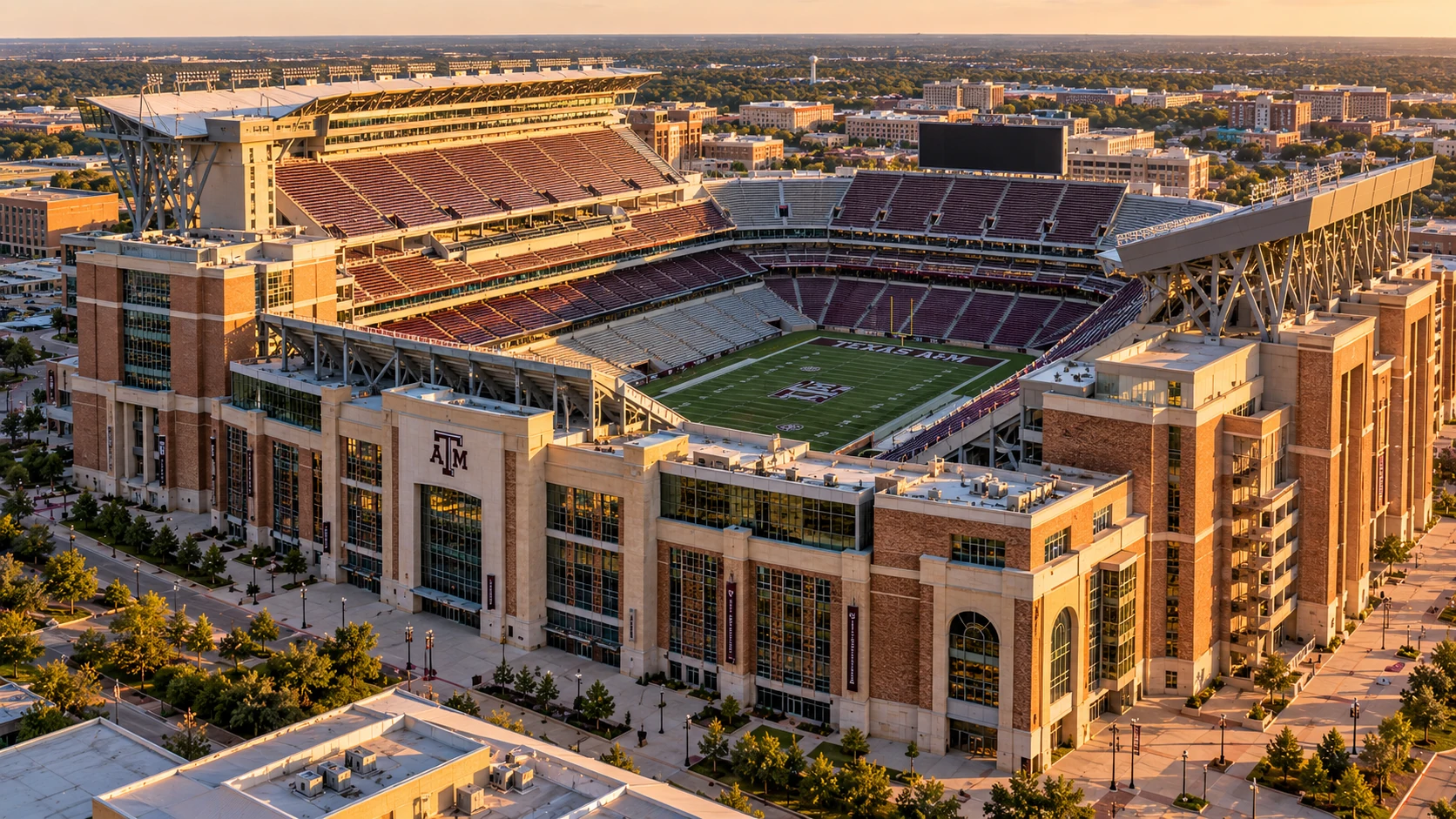 Architectural aerial of Kyle Field, Texas A&M stadium grandstands, exterior, and College Station campus at golden hour